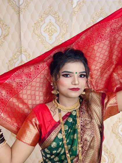 The final look for a wedding guest, styled in a traditional green and red saree. The makeup is elegant and the hair is pulled back into a soft bun, allowing the jewelry to stand out.