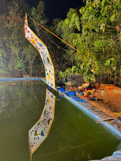 The climbing wall reflected in the pool at night. This image captures the calm after the storm and the unique, artistic beauty of our setup at Varanashi Farms.