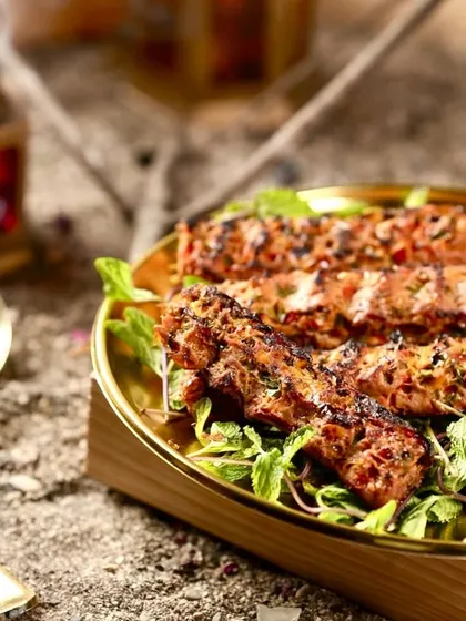 A close-up of my signature Mutton Adana Kebab, grilled to perfection. Each kebab is prepared using authentic techniques, resulting in a smoky flavor and incredibly juicy texture that melts in your mouth.