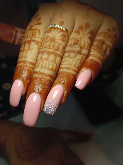 Another view of these pretty peach bridal nails, showing how the square shape and subtle glitter accent complement the intricate henna design.