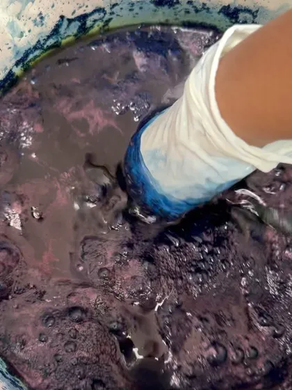 Stirring the indigo vat. This is a living dye bath that requires care and attention. The process is a mix of science and art, and it's fascinating to watch the chemistry unfold.