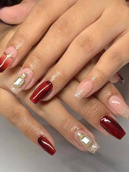 A regal design combining deep red, glitter, and gold perfume bottle charms. This is a perfect example of creating a luxurious and themed nail set.