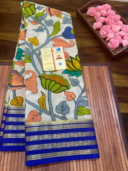 A beautiful lotus print Kalamkari Mysore silk saree on a white base with a blue border.