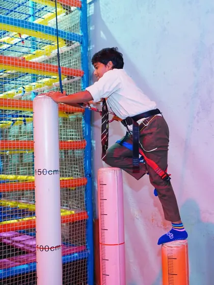 Another student tackles the climbing pillars, a popular attraction during school outings for its unique challenge.