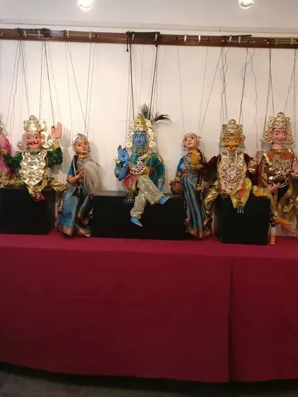 A display of royal puppets, including Lord Krishna and other kings from mythology. The golden breastplates, intricate crowns, and rich fabrics showcase the regal nature of these characters.