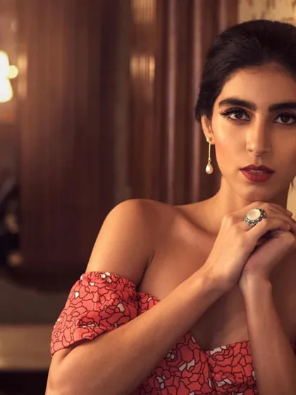 This vintage-inspired look features a beautiful floral off-shoulder dress. The styling is kept classic with pearl drop earrings and a bold red lip, perfect for a romantic dinner or a special evening out.