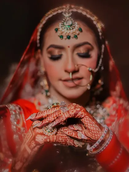 The details tell a story of their own. This close-up shot focuses on the intricate mehndi design and bridal jewelry, highlighting our commitment to capturing every element you've carefully chosen for your wedding day.