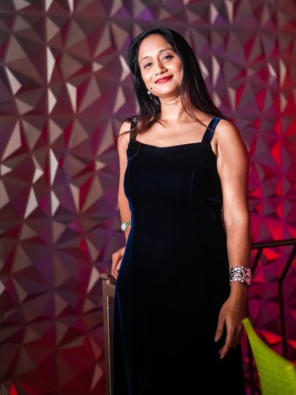 An elegant guest posing against the red-lit feature wall.