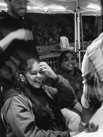 A candid black and white photo capturing the genuine laughter of guests at an event as they see their caricature.