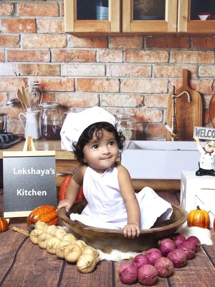 A fun and unique chef-themed sitter session. Dressed in a little chef's hat, this baby is the star of her own kitchen, complete with a brick wall backdrop and cooking props.