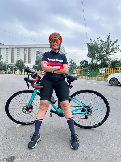 A rider standing proudly with her bike after completing a tough Sunday ride.