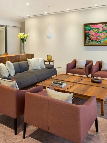 The living area in the Limestone Residence is a composition of clean forms and warm tones. The arrangement of furniture encourages conversation, while the large artwork adds a vibrant focal point to the serene space.