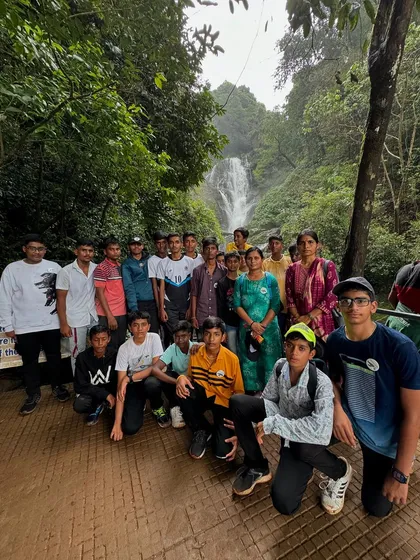 A group of students at a beautiful waterfall, combining learning with fun and adventure. I ensure a balanced itinerary for all my school trips.