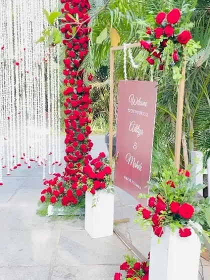 A dramatic and romantic Muhurtham setup. We used columns of deep red roses and hanging golden kaleeras to frame the welcome signage, setting a luxurious tone from the very first glance.