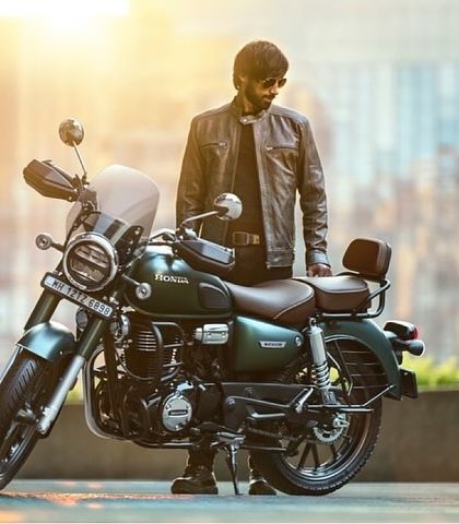 This image from the Honda CB 350 ad campaign features a model in a grey leather jacket. The styling is clean and modern, designed to complement the sleek green and chrome details of the bike.