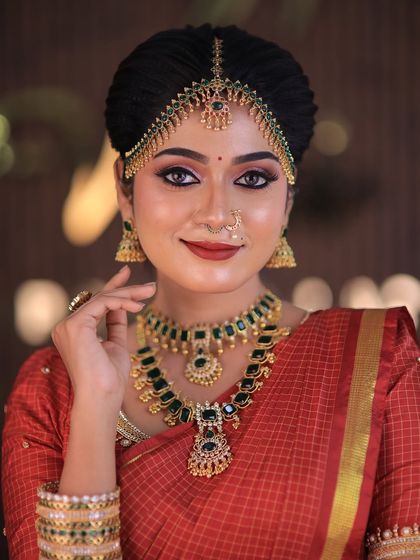 Model Swetha in a red checked silk saree. This traditional drape is perfect for showcasing classic South Indian bridal looks for catalogues or campaigns.