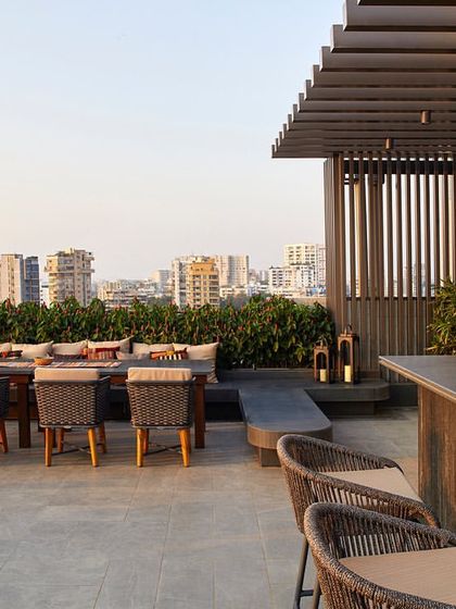 The city-facing side of the terrace includes a bar and dining space, designed with resilient outdoor furniture and strategic landscaping.