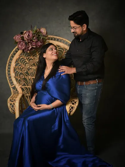 A classic seated portrait in a peacock chair, which adds a touch of bohemian elegance. The interaction between the couple feels natural and loving, making for a timeless image.