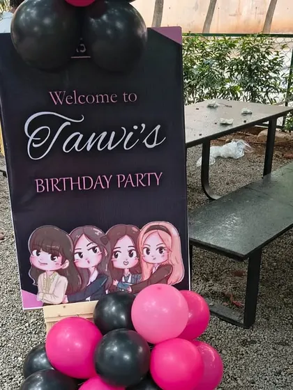The welcome sign for the black and pink themed party, featuring cartoon illustrations of the birthday girl's favorite band.