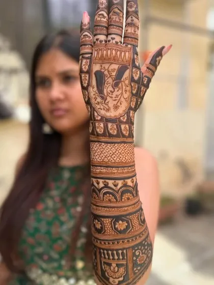 A custom design featuring a portrait of the client's choice on the palm, surrounded by traditional patterns.