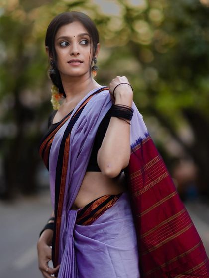 This pose showcases the rich, striped pallu of the Ilkal saree, a defining feature of this beautiful craft.
