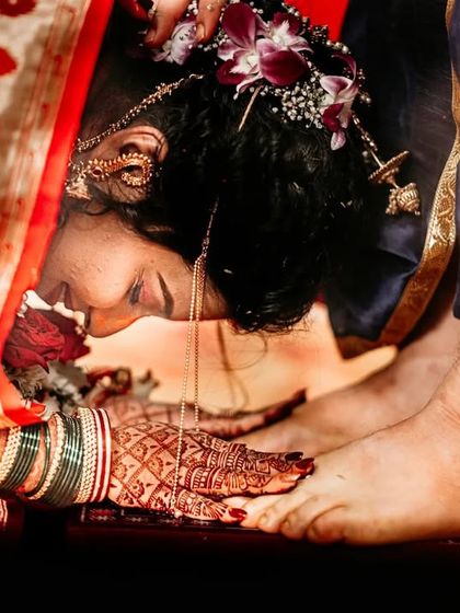 A bride touches her husband's feet, a traditional sign of respect in some Marathi wedding customs. I focus on capturing the emotion and belief behind these rituals.