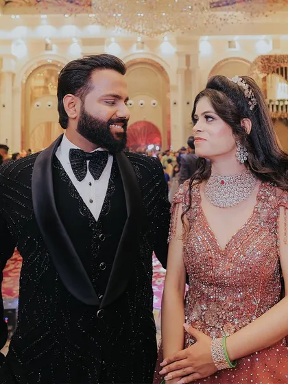 A classic portrait of the couple on their engagement night. Their matching smiles and elegant attire are perfectly captured against the grand backdrop of the venue.