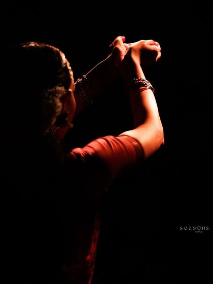 A dramatic, low-light photograph capturing the form and posture of a dance piece. The interplay of light and shadow can create such a powerful mood on stage.
