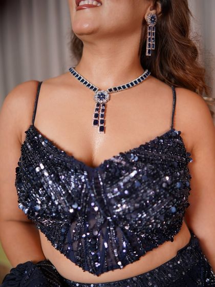 A close-up of the jewelry and blouse for my brother's engagement. The navy blue statement necklace is monochromatic, creating a polished effect that complements the sequined blouse without competing with it.