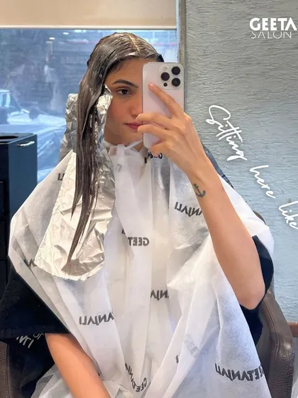 A client taking a selfie while her foils are in, capturing the "sitting here like" moment of a hair colour appointment.