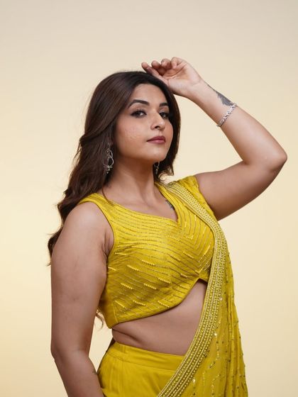A close-up of the yellow pre-draped saree, showing off the flattering cut of the blouse and the delicate draping.