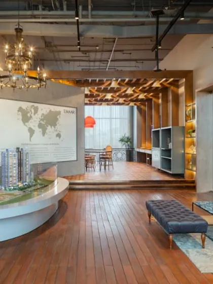 Another view of the Emaar DigiHomes centre, showing how the wooden flooring unifies the different zones, from the architectural model display to the casual lounge seating area.