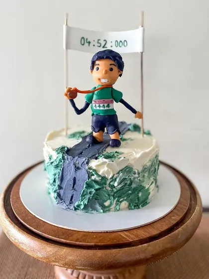 I love making cakes that celebrate personal achievements. This one was for a marathon runner, complete with a custom fondant figurine and a banner showing his exact finish time. It’s these personal details that make a custom cake so special.
