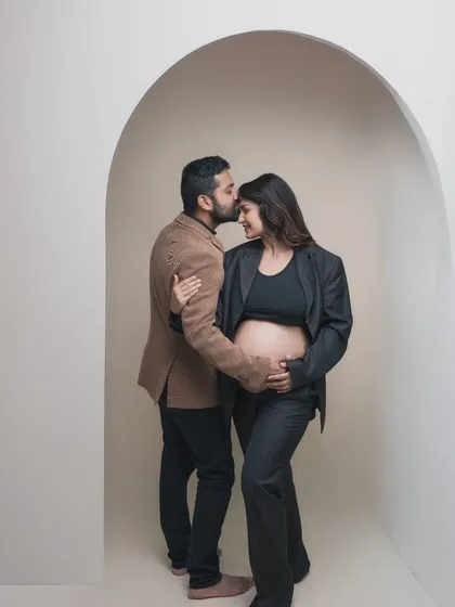 Framed by an archway, this intimate moment feels like a private world. His gentle kiss on her forehead is a gesture of pure love and protection. The modern, minimalist setup is both chic and timeless.