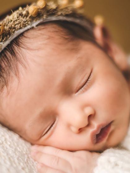 A close-up shot capturing the perfect, peaceful features of a newborn baby girl. Her delicate skin and gentle sleep are the focus of this timeless portrait.