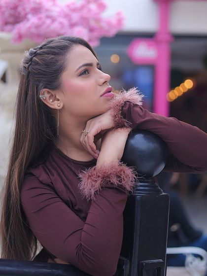 A beautiful portrait of a model at an outdoor cafe, using the natural light and floral background to create a soft, dreamy look.