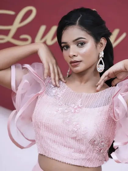 A beautiful pose that highlights the delicate embroidery on the blouse and the sparkling statement earrings.