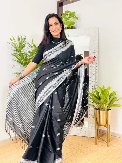 A classic black Khadi cotton saree with white woven motifs. This is a very elegant and timeless piece that exudes sophistication.