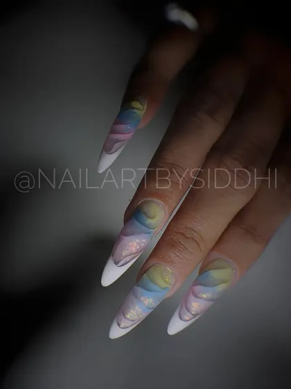 Extra-long stiletto extensions with a 3D inbuilt pastel rainbow design, showcasing a complex and artistic extension technique.