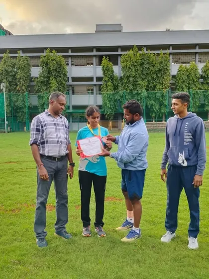 A coach presenting an athlete with her certificate for her outstanding performance in distance running events.