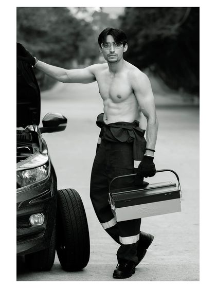 A conceptual men's fitness portrait. The black and white treatment accentuates the subject's physique and the gritty, determined mood of the shot.