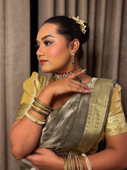 A side profile showing the traditional hairstyle with flowers (gajra) and jewelry for a South Indian themed event. It's all about authenticity.