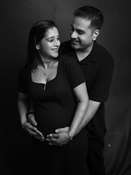 The joy between two people. This black and white couple's portrait uses dramatic lighting to highlight their happy smiles and the intimate bond they share.