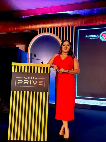 Leaning against the podium at the Ajmera Privé event, exuding confidence.