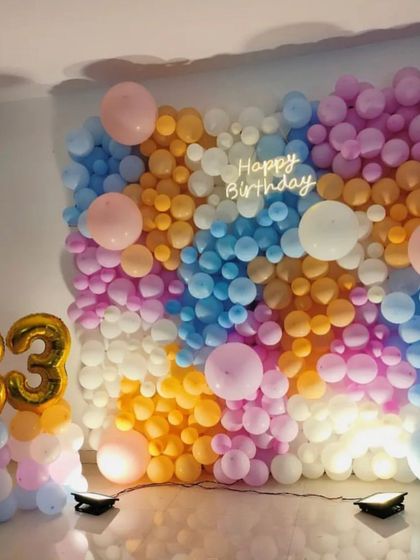 A vibrant and joyful wall of balloons for an 83rd birthday. This colorful backdrop and foil number balloons create a cheerful and celebratory photo spot.