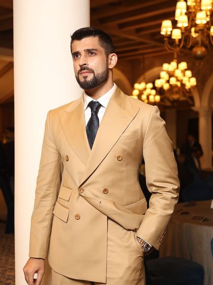 A candid shot of a guest at our Zegna event. The elegant drape of his double-breasted suit jacket highlights the superior quality of the fabric and the precision of our tailoring.