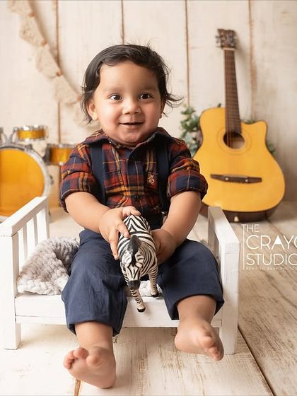 Taking a break from the music to play with a toy zebra, this little one is adorable on his miniature bed prop.