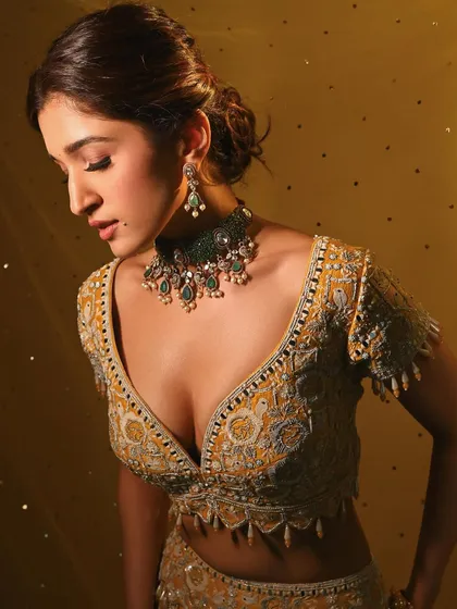 A downward glance that showcases the beautiful eyeshadow and long lashes. The lighting highlights the dewy finish on the skin.
