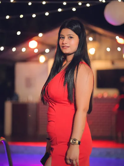 A portrait from a poolside party, capturing a confident look in a vibrant red dress.