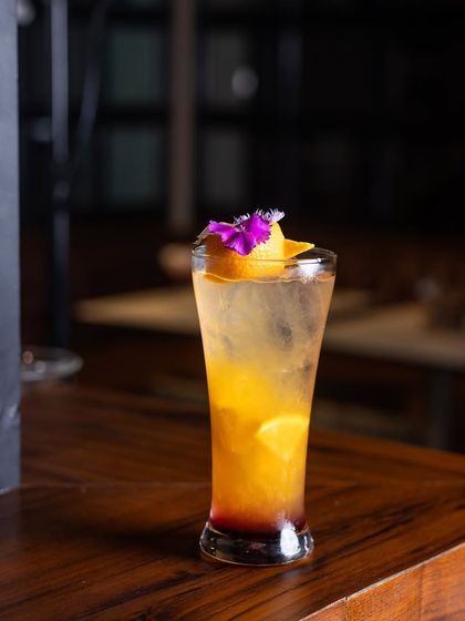 The Tropical Song Bird is a delightful mocktail with flavors of fresh mango and orange chunks.